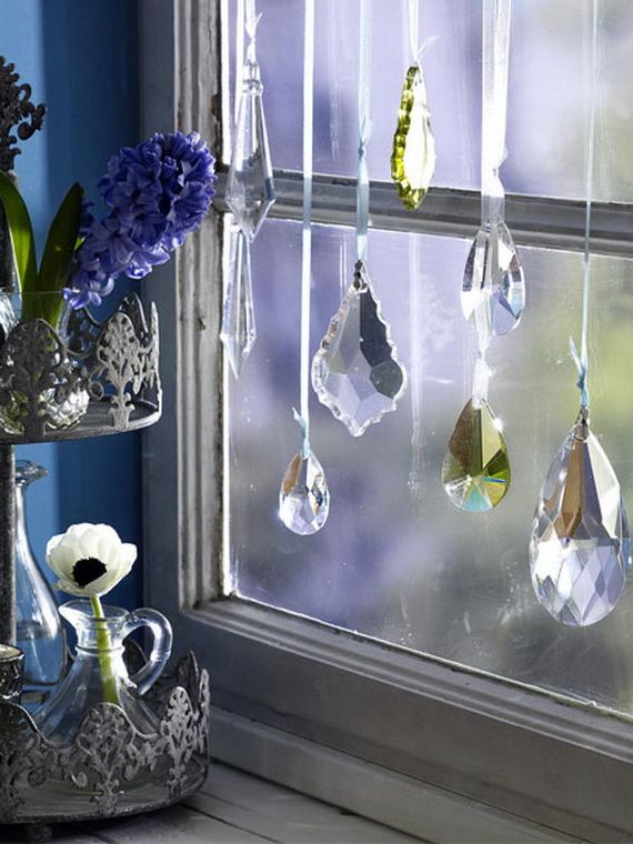 crystals hanging in a window with fishing line and ribbons